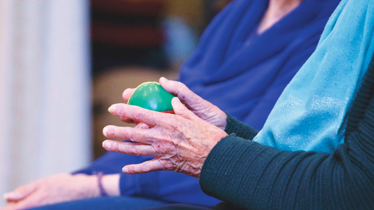 Manos de una persona mayor trabajando con una pelota de rehabilitación