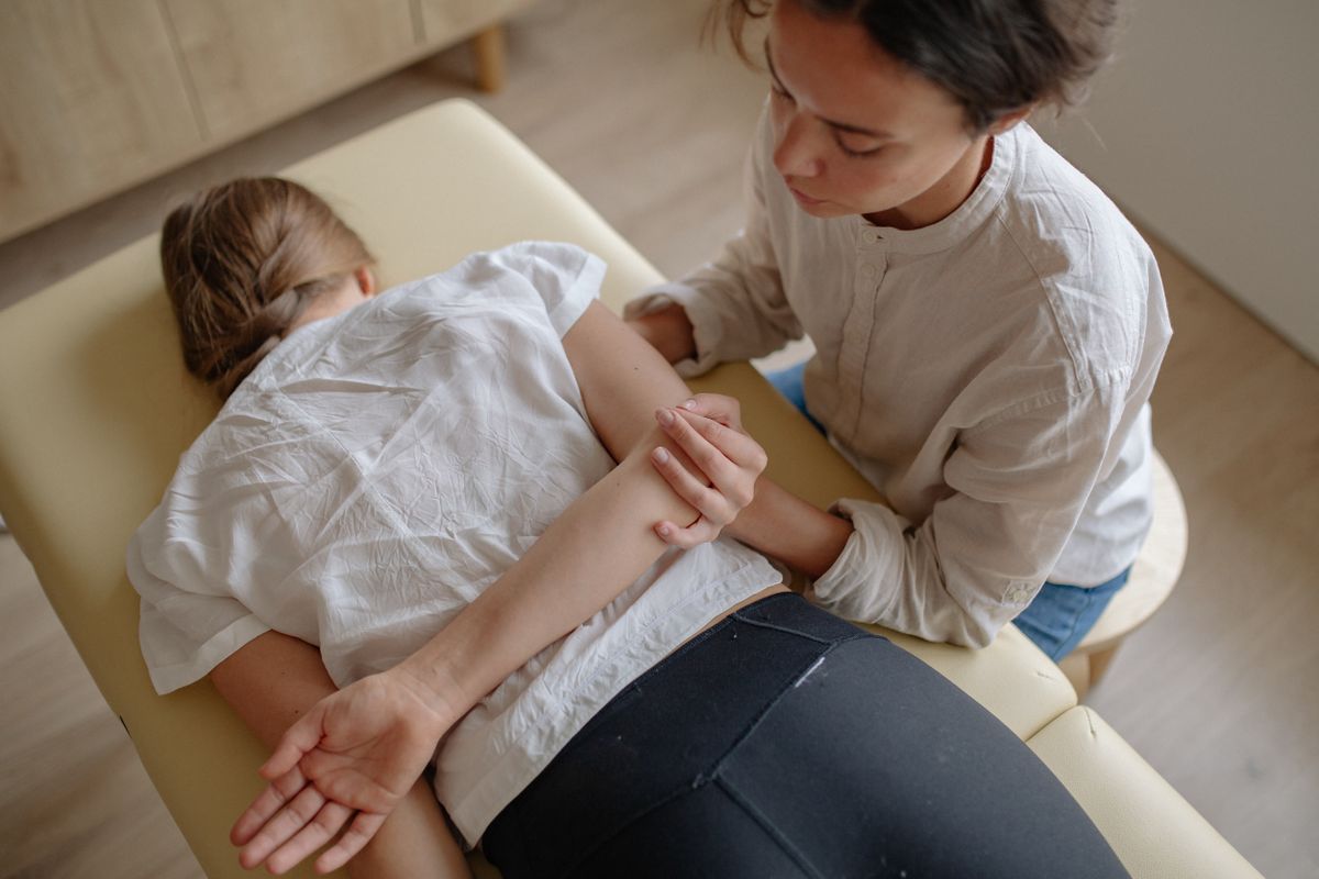 Fisioterapeuta tratando la espalda de una paciente con dolor persistente